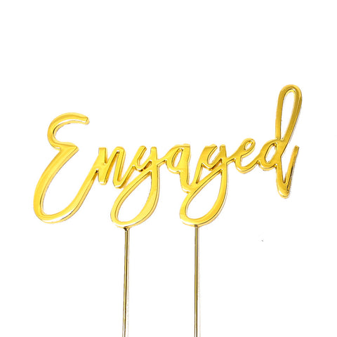 Metal cake topper with the word Engaged in Gold