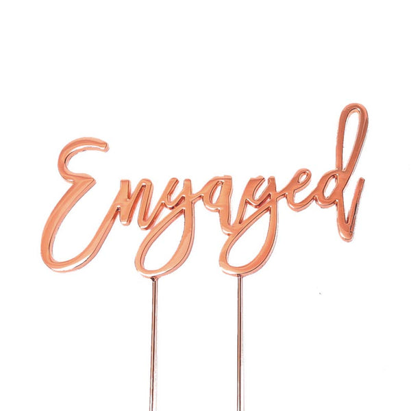 Metal cake topper with the word Engaged in Rose Gold