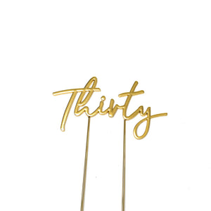 Metal cake topper with the word Thirty in Gold